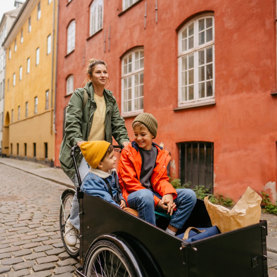 Kvinde cykler med børn